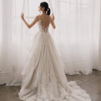 bride in a wedding gown looking out a window